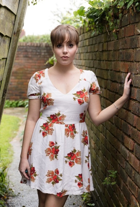 Amateur girl with pierced nipples takes a pee in alleyway between houses