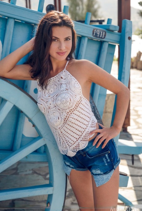 Petite teen Jasmine Jazz doffs cutoffs while getting naked by a wagon wheel