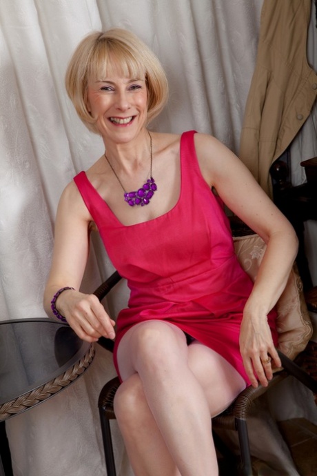 Mature blonde with lovely breasts Hazel takes off her dress & shows hairy muff