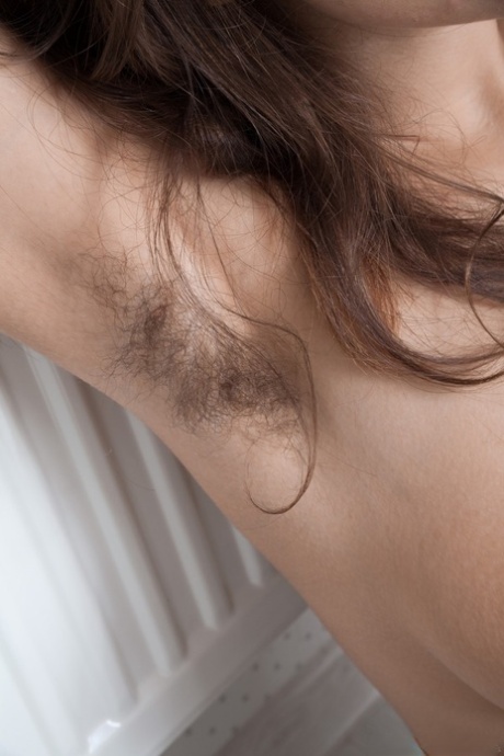 Brunette solo girl shows off her unshaven armpits and twat in her bedroom